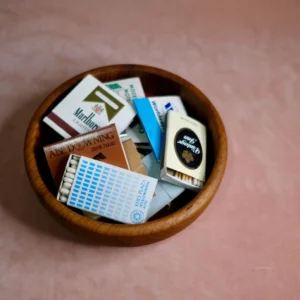 assorted vintage matchbooks in wooden bowl